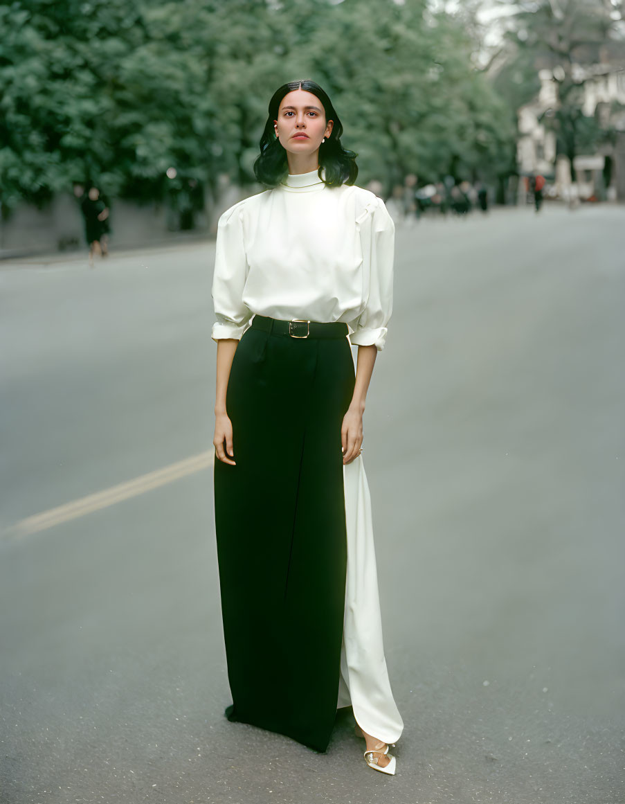 Elegant woman in white blouse and black trousers on street