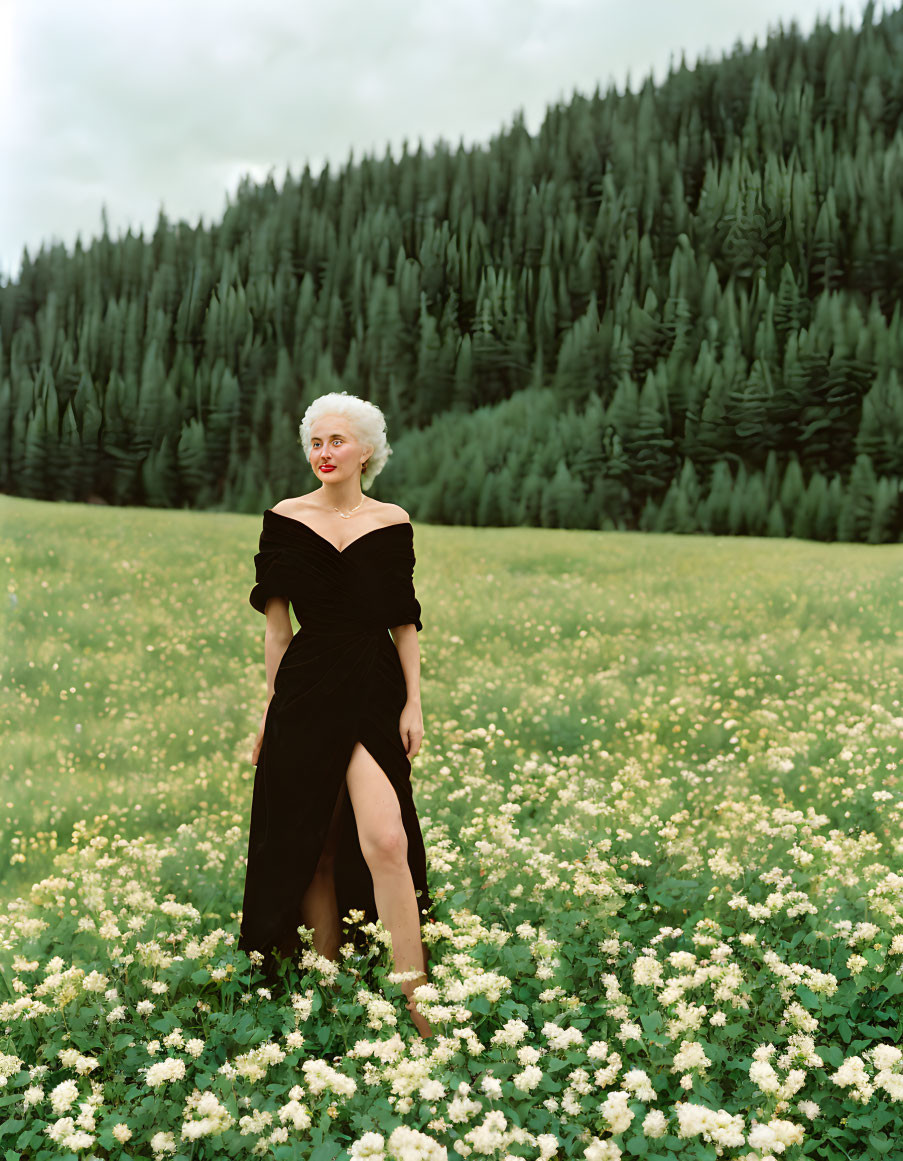 Woman in black dress amidst white flowers in forest setting