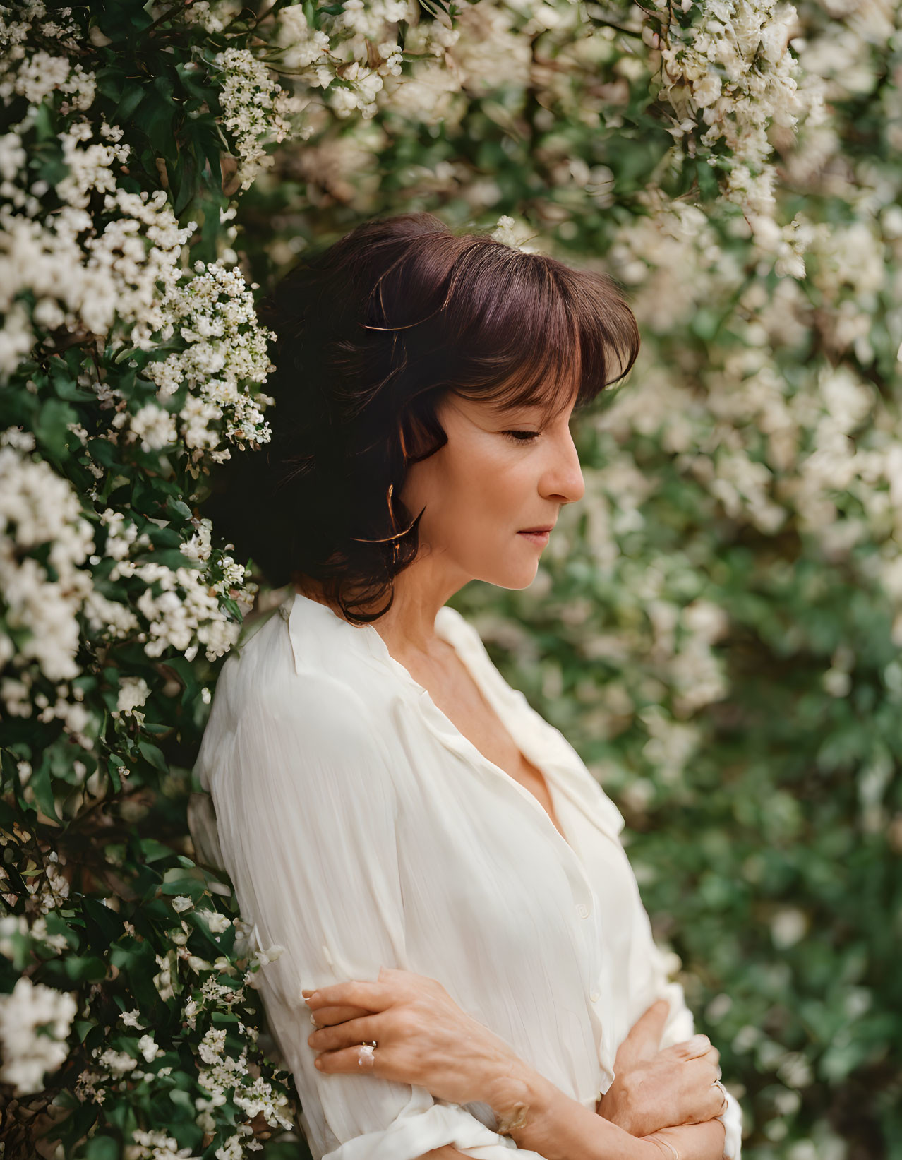 Woman in White Blouse Surrounded by Blooming Flowers