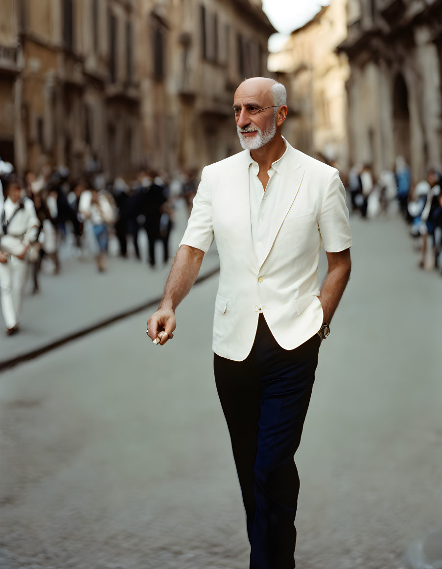 Bald man in white jacket and blue trousers walking on cobblestone street