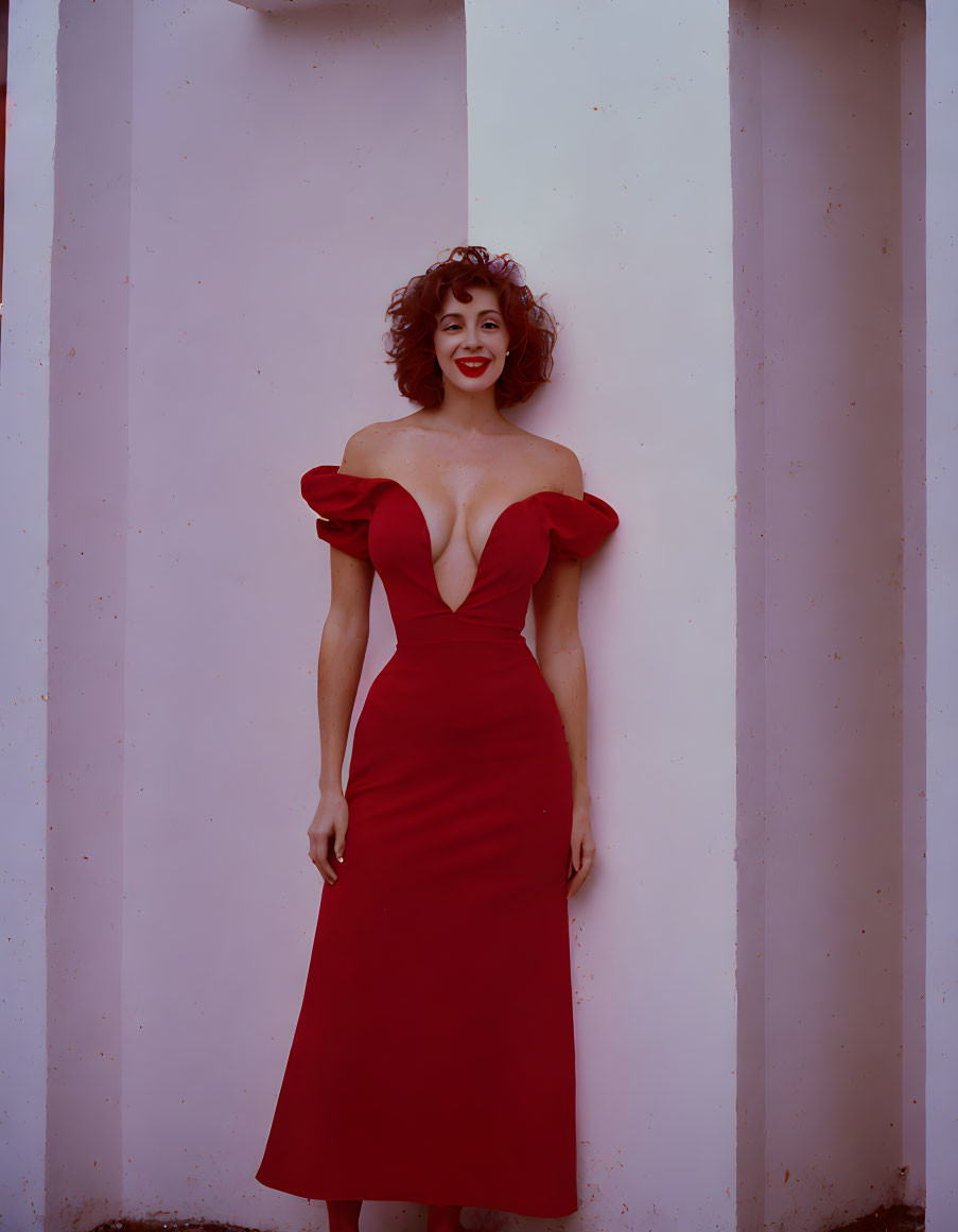 Woman in Red Off-Shoulder Gown Smiling on Pale Pink Background