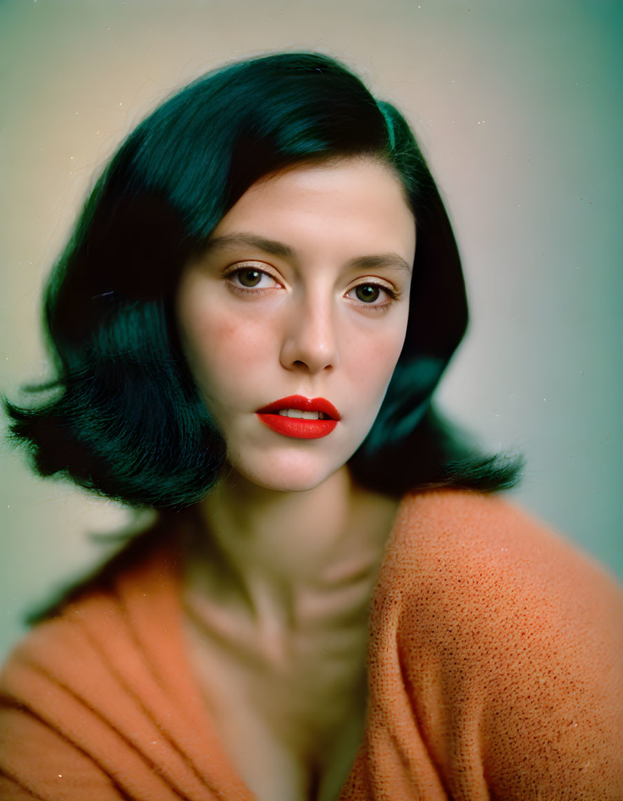 Portrait of Woman with Dark Bobbed Hair and Red Lipstick in Orange Garment