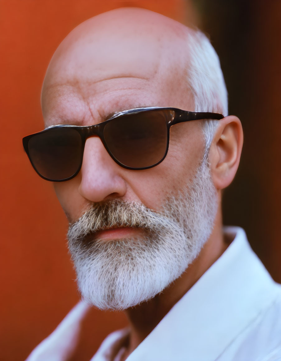 Bald Man with White Beard and Sunglasses on Red Background