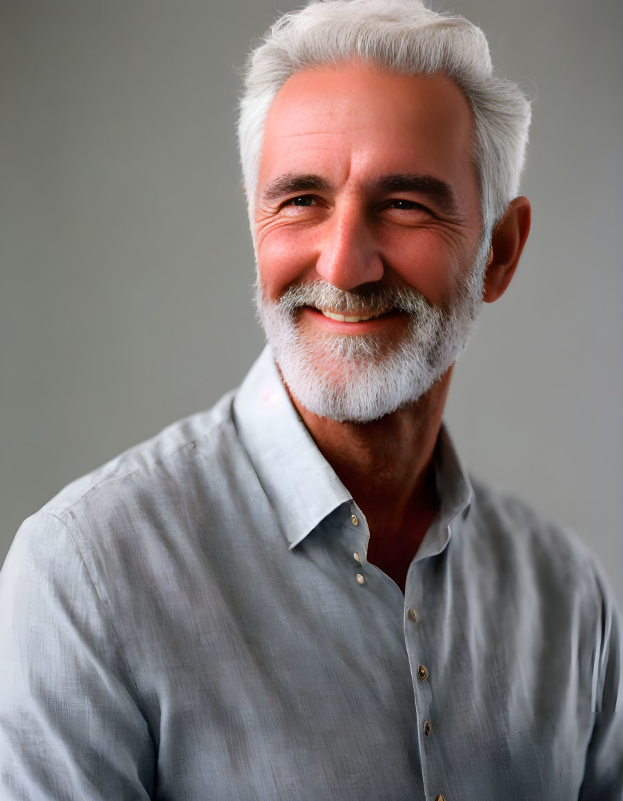 Elderly man portrait with white hair and beard in light gray shirt