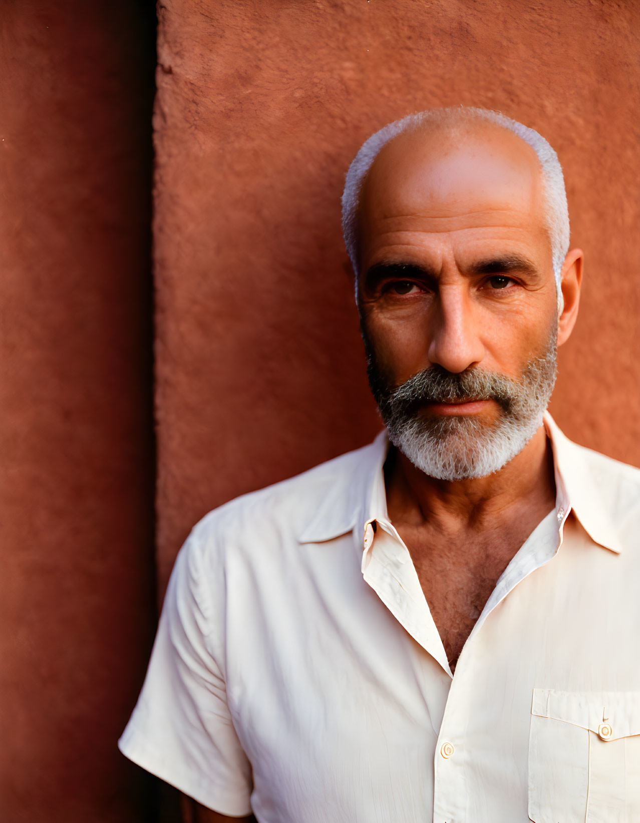 Elderly man portrait with white beard and balding head in white shirt