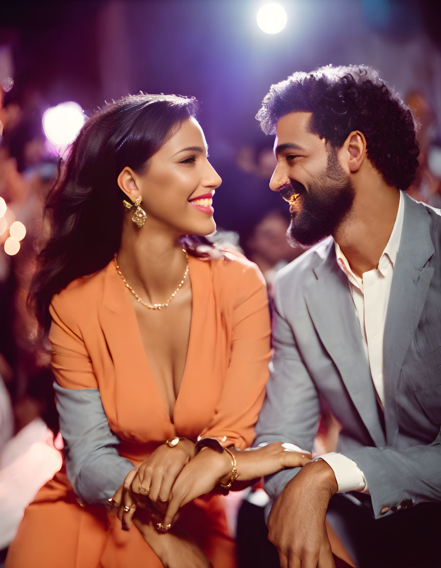 Happy couple sitting closely in front of festive background