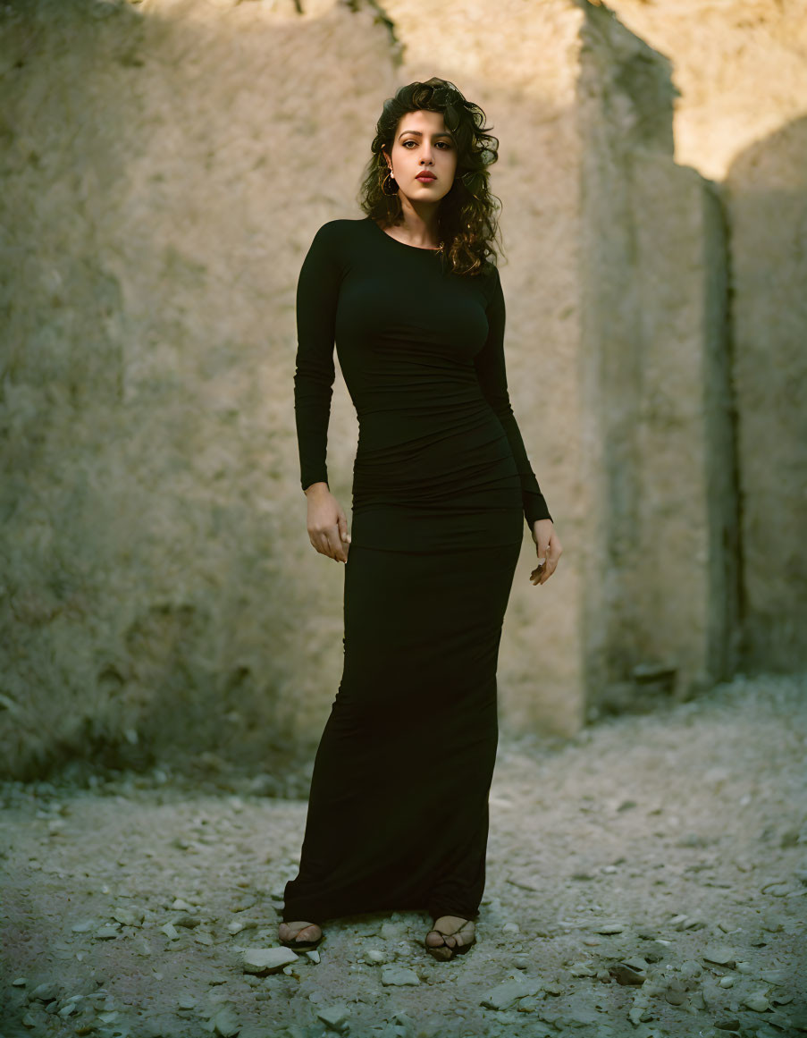 Woman in Black Dress Stands Between Narrow Walls