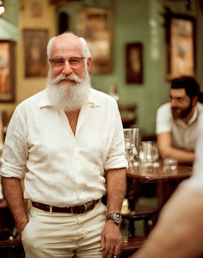 Elderly man with white beard and glasses in warmly lit bar