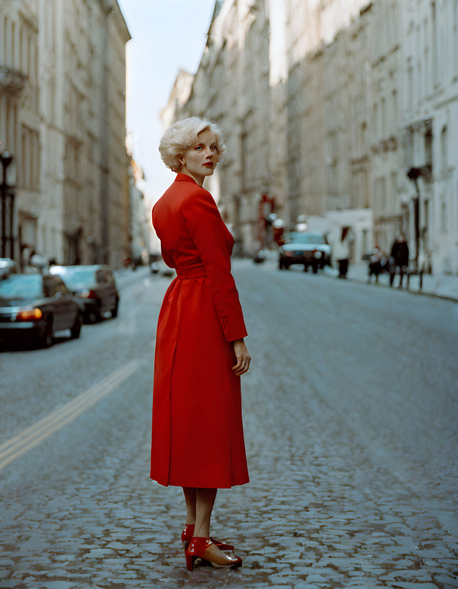 Blonde woman in red dress and heels on old city street