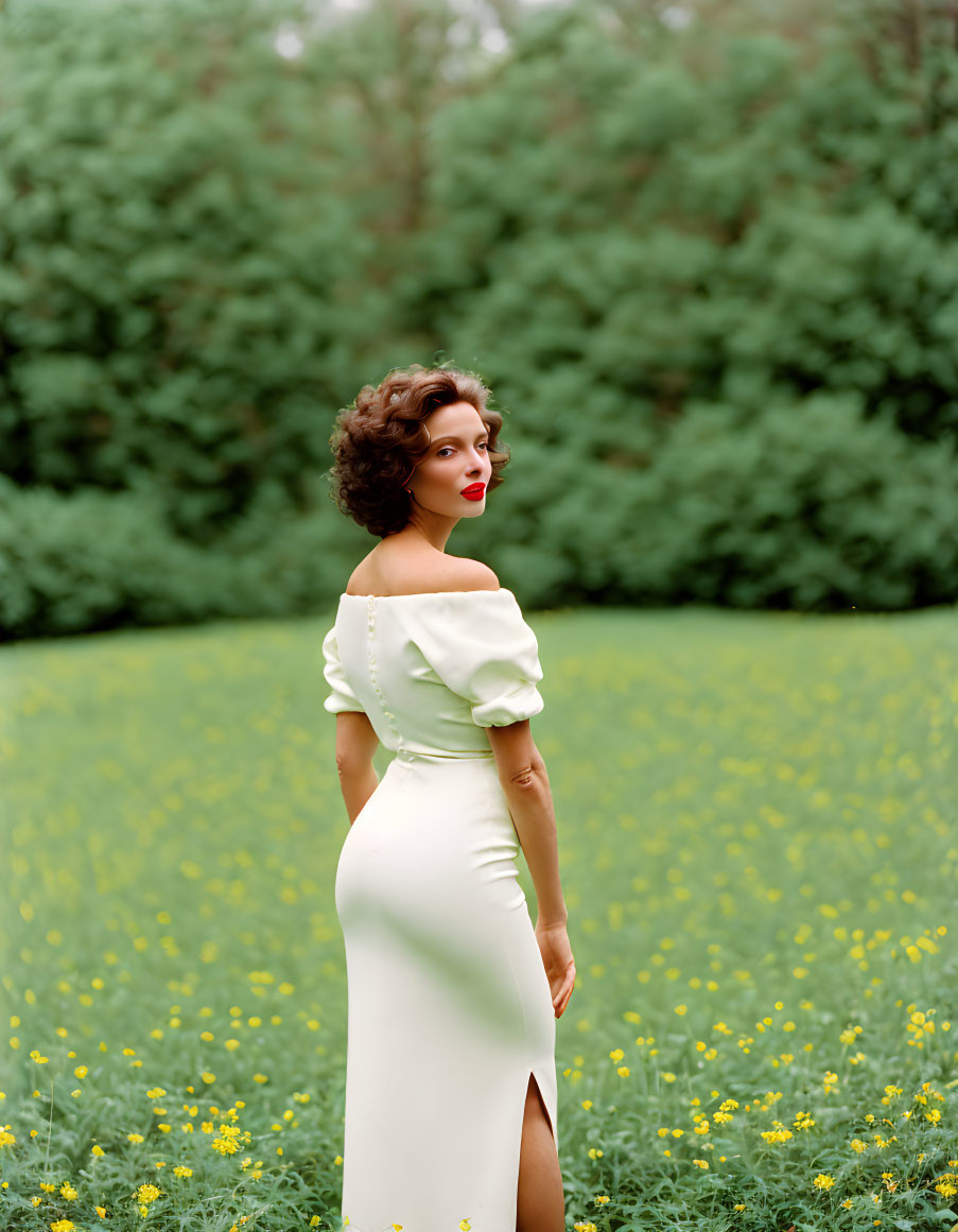 Woman in off-shoulder white dress among yellow flowers with vintage hairstyle