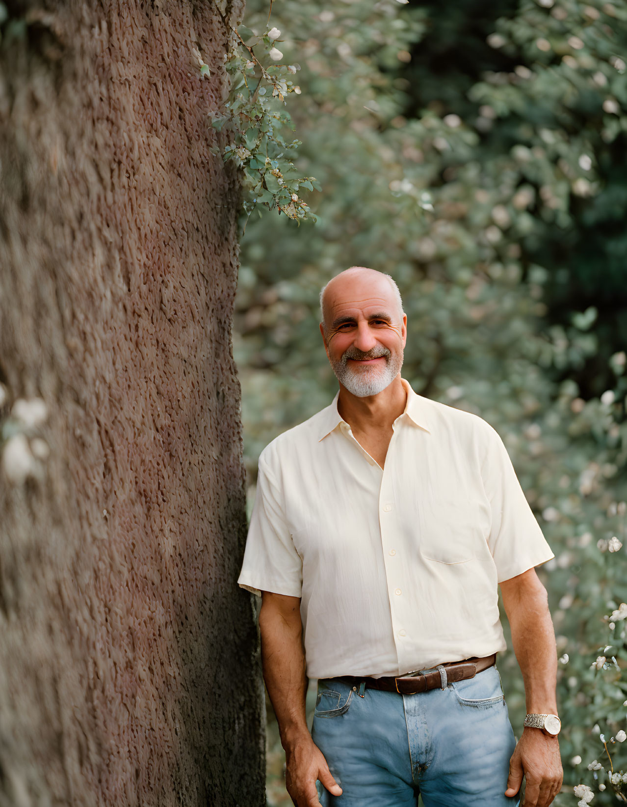 Bald Man Smiling in Yellow Shirt by Tree