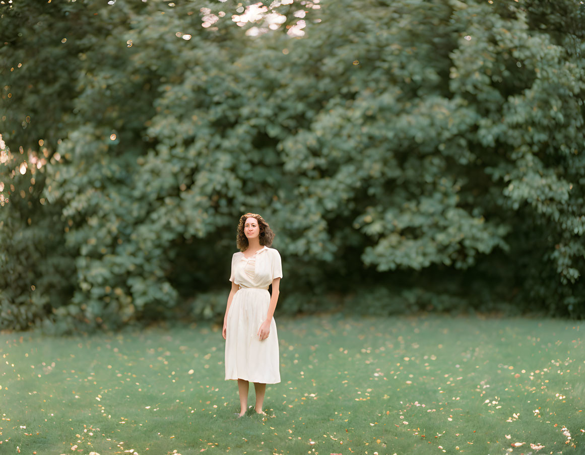 Woman in White Dress Standing in Green Field with Yellow Flowers