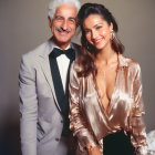 Smiling man in tuxedo and woman in satin blouse pose together