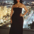 Woman in Black Strapless Gown with Red Lipstick and Gold Jewelry in Night Cityscape