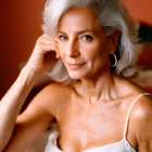 Senior Woman in Silver Hair and Hoop Earrings Poses in White Lace Outfit