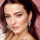 Styled hair, makeup, and elegant earrings on woman against pink background