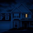 Nighttime scene: solitary house, one lit window, dark blue sky