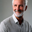 Elderly man portrait with white hair and beard in light gray shirt