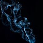 Blue smoke swirling elegantly on dark background