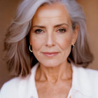 Gray-Haired Woman in White Outfit with Gold Earrings