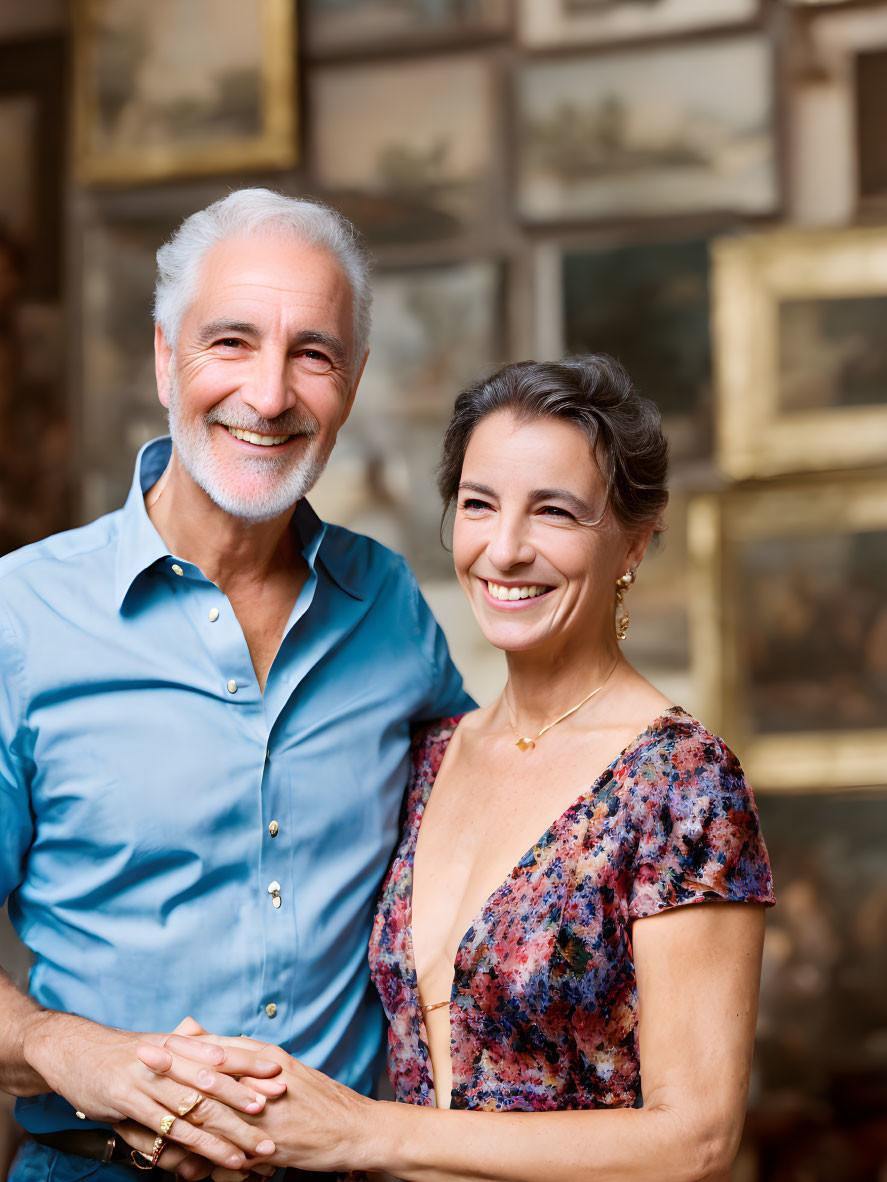 Elderly couple embracing in front of a painting