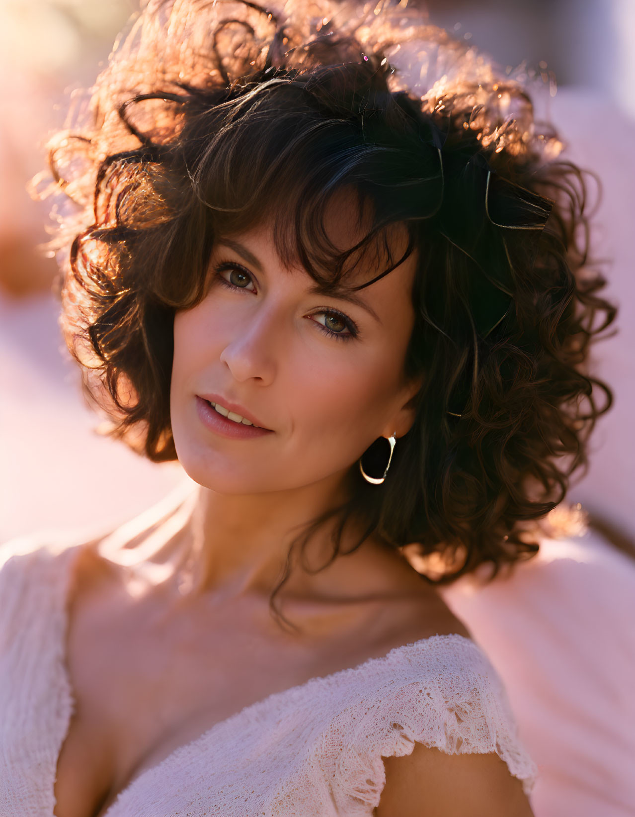 Curly Haired Woman Smiling in Warm Backlight