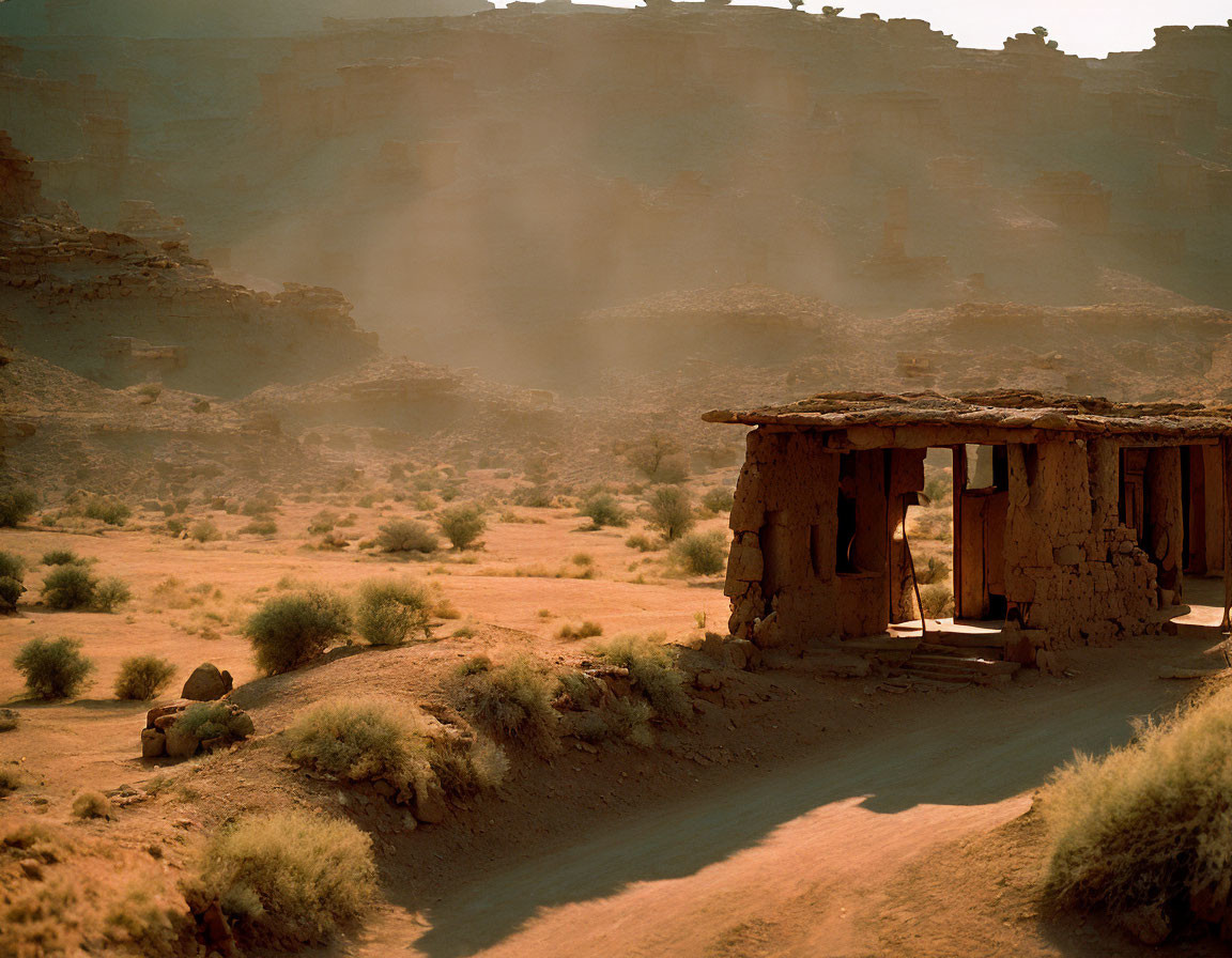 Deserted structure in arid desert with layered rock formations