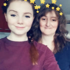 Two girls with starry headbands and curly hair in soft background.