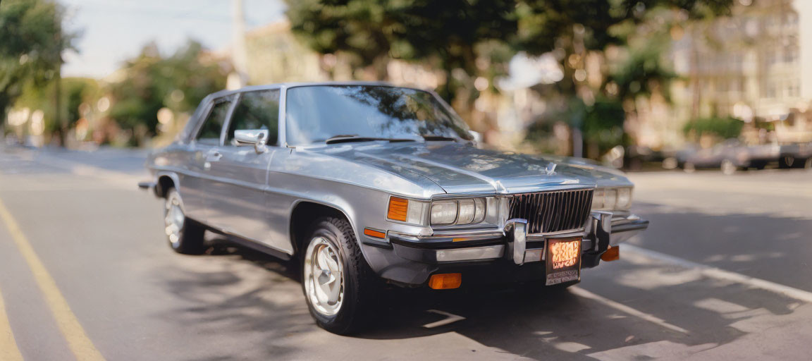 Vintage Silver Car Parked on Sunny Street with Blurred Background