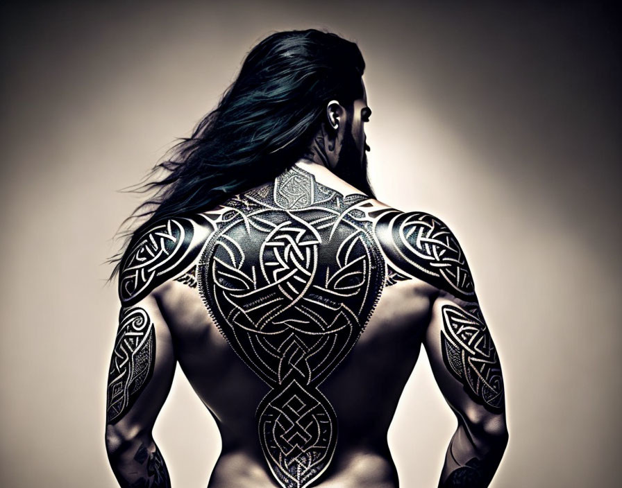 Man with Long Hair and Back Tattoos in Monochromatic Artistic Scene