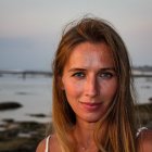 Woman with Crown Posing by Seaside at Dusk