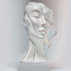 Stylized female face sculpture with flowing hair and closed eyes