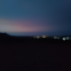 Twilight landscape: rolling hills, distant sea, and tranquil sky