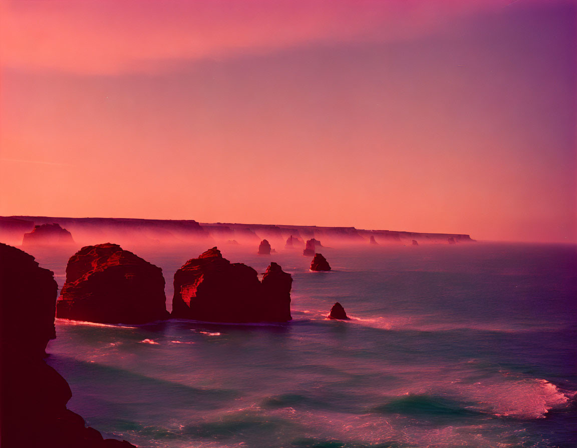 Scenic coastal view at dusk with rock formations and cliffs under purple-pink sky