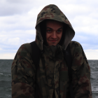 Person in tactical gear holding rifle under cloudy sky