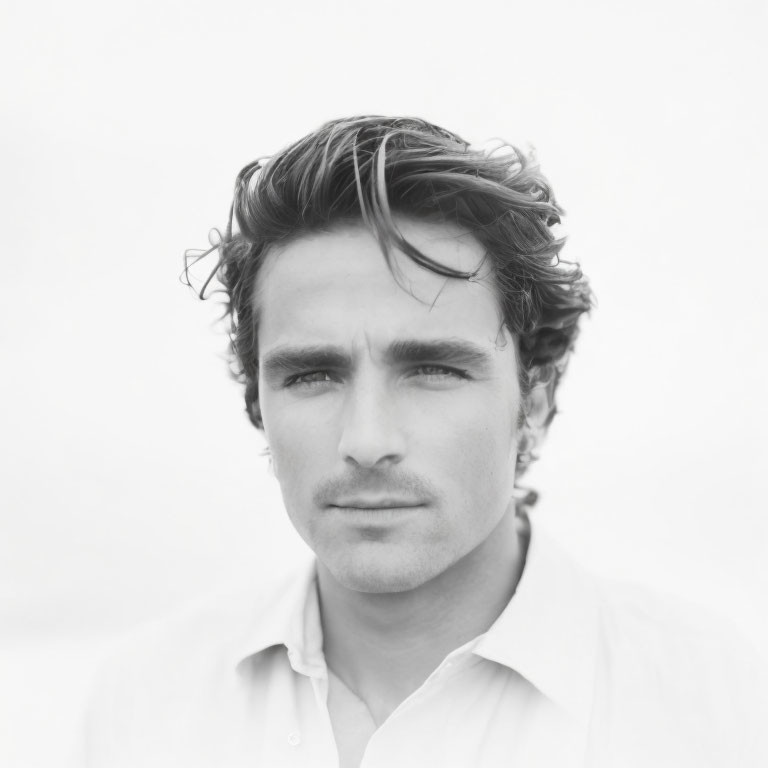 Monochrome portrait of man with tousled hair in white shirt