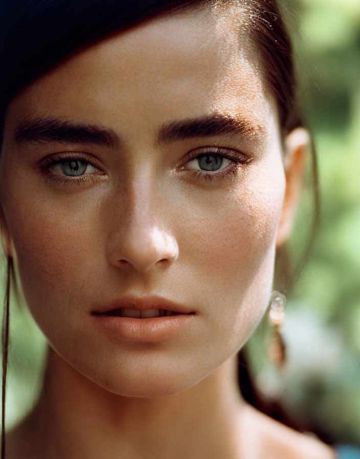 Portrait of a Woman with Striking Blue Eyes and Dark Eyebrows