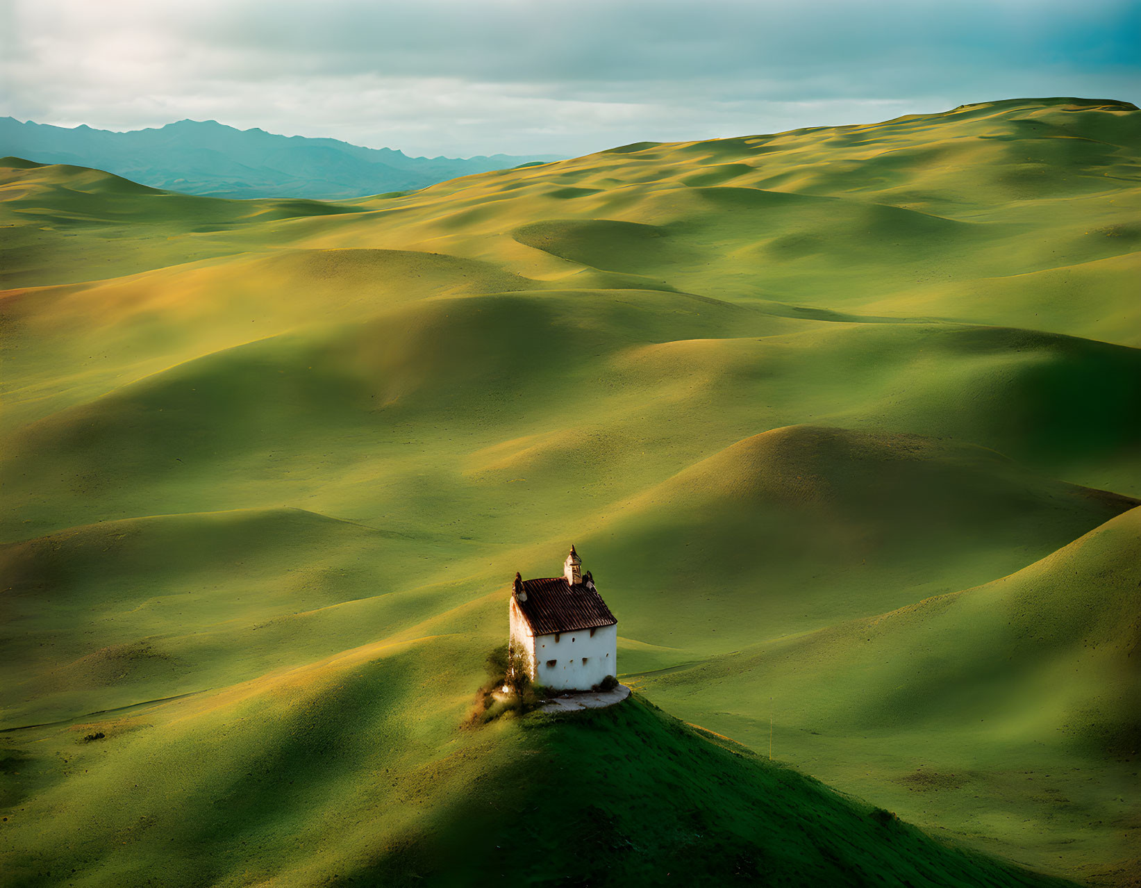 White House with Red Roof Surrounded by Green Hills and Dynamic Sky