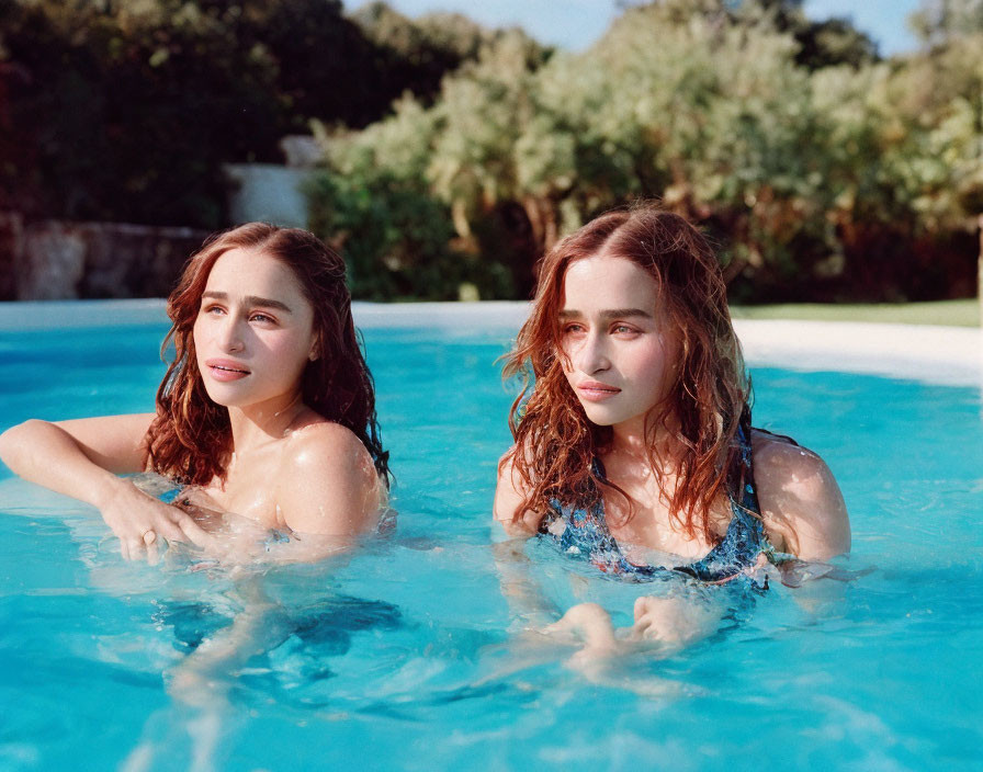 Two Similar Individuals Swimming in Clear Pool Amid Greenery