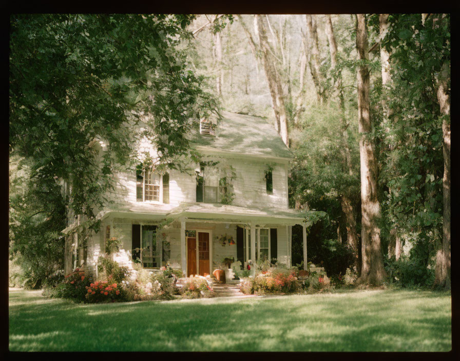 White two-story house with porch in green setting