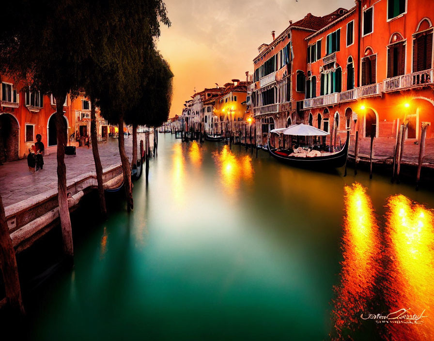 Vibrant sunset over Venetian canal with illuminated buildings and gondola.