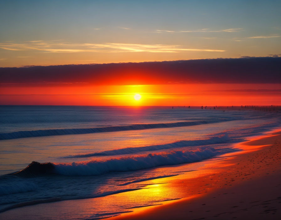 Vibrant red and orange sunset over ocean beach scene