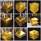 Nine gold metal puzzle models of buildings against book spines