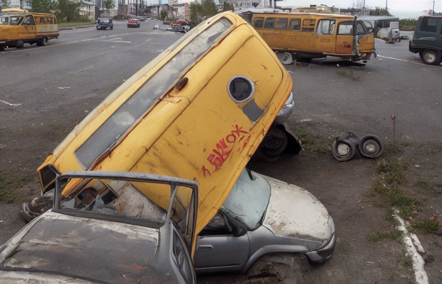 Yellow van tipping onto silver car in parking lot with nearby vehicles