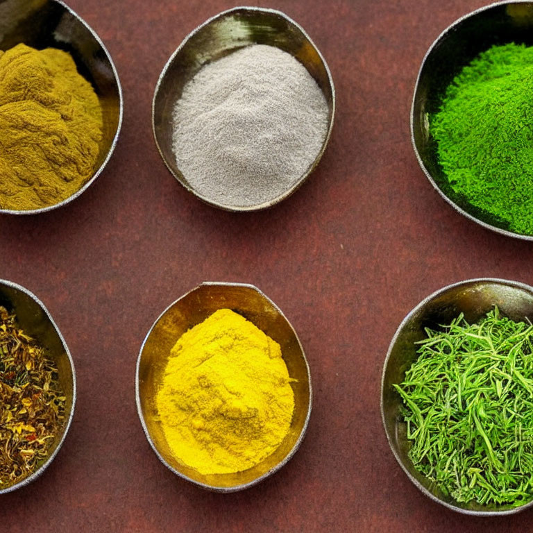 Six Colorful Spices and Herbs in Small Bowls on Dark Red Background