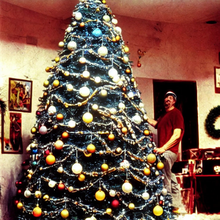 Festive room with person beside large Christmas tree