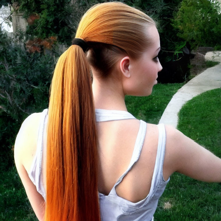 Auburn-Haired Person in High Ponytail Outdoors with Greenery