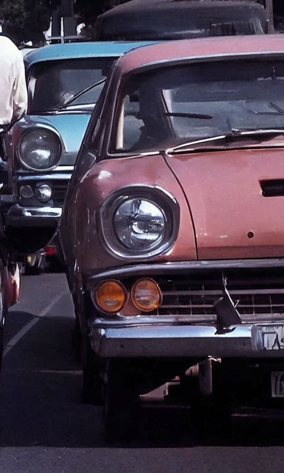 Classic Cars Displayed with Pink Car's Front Grille and Headlights