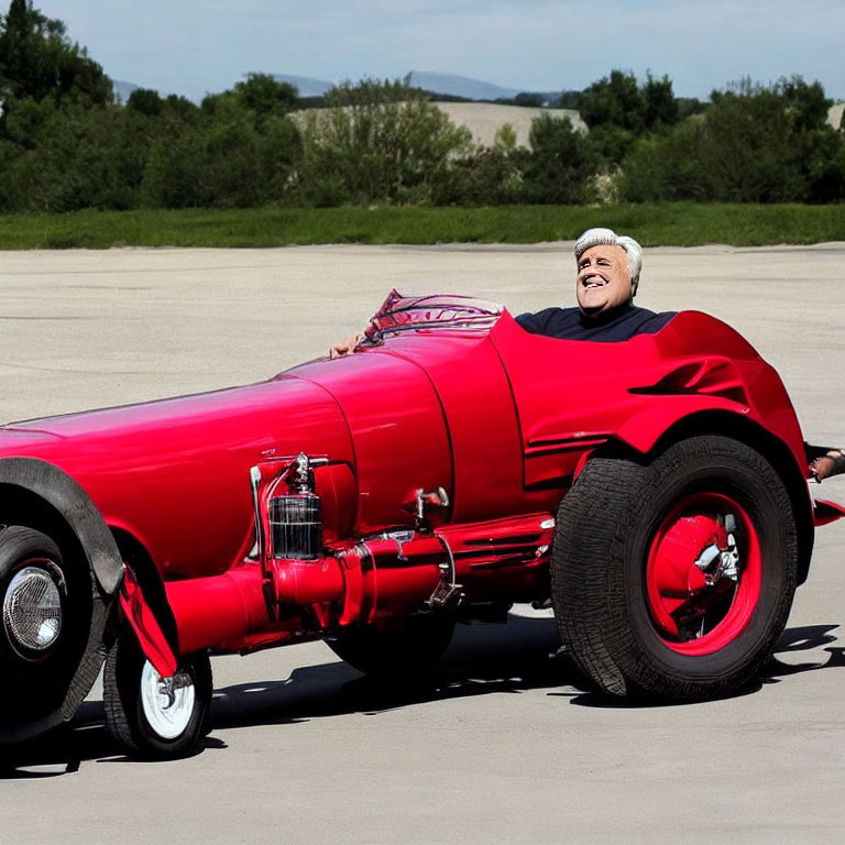 Smiling person in vintage race car on clear day