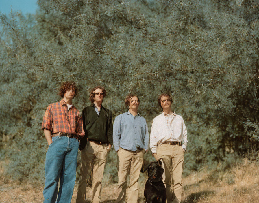 Four Men and Black Dog Outdoors with Trees in Background